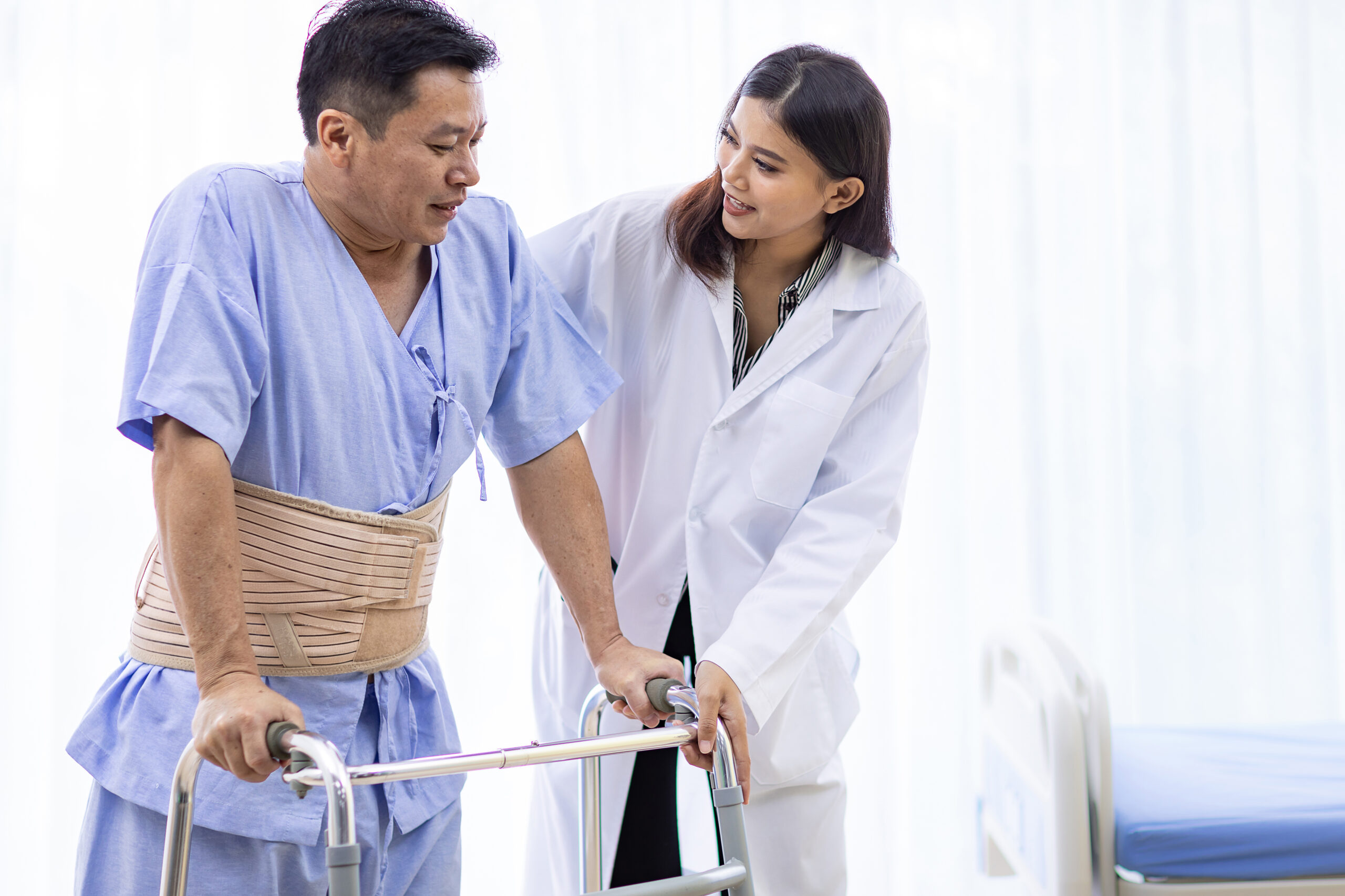 lady doctor help elderly using adult walker in hospital