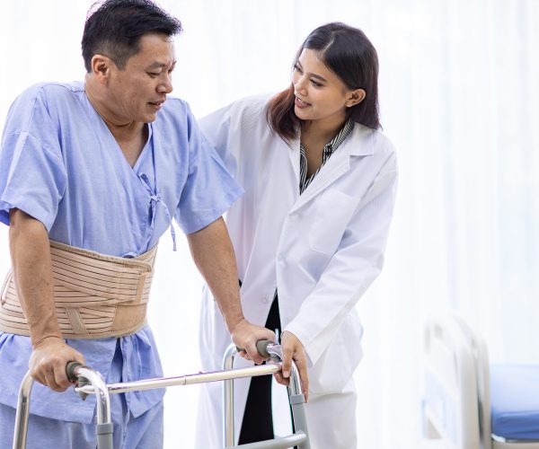 lady doctor help elderly using adult walker in hospital
