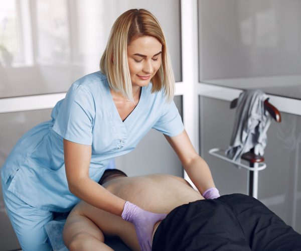 The doctor massages the man in the hospital